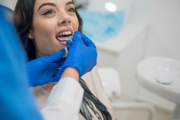 a woman getting her teeth checked by a dentist.